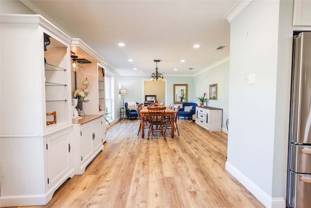 dining space with light hardwood / wood-style flooring and crown molding