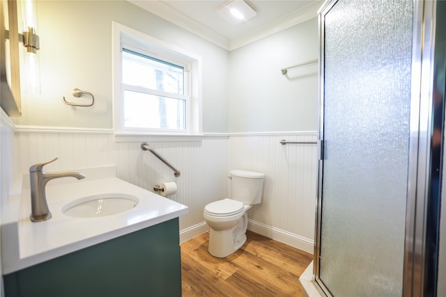 bathroom with a shower with shower door, vanity, toilet, hardwood / wood-style flooring, and crown molding