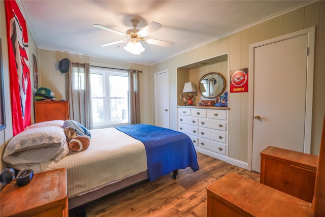 bedroom featuring ceiling fan, hardwood / wood-style flooring, and crown molding