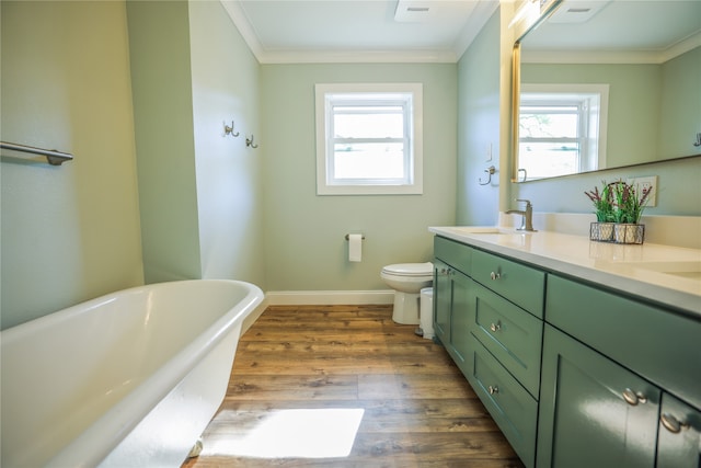 bathroom with toilet, plenty of natural light, crown molding, and a bath