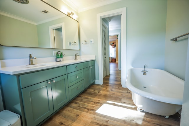 bathroom featuring crown molding, a bathtub, wood-type flooring, and vanity