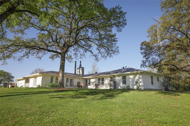 back of property featuring a lawn and french doors