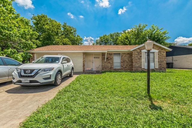 single story home featuring a garage, concrete driveway, a front lawn, and brick siding