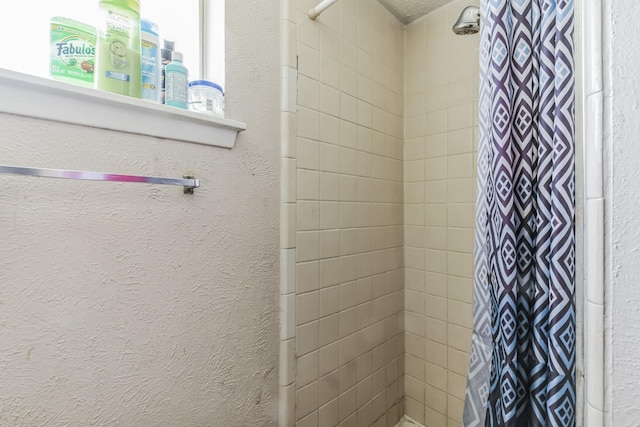 full bath with a textured wall and tiled shower