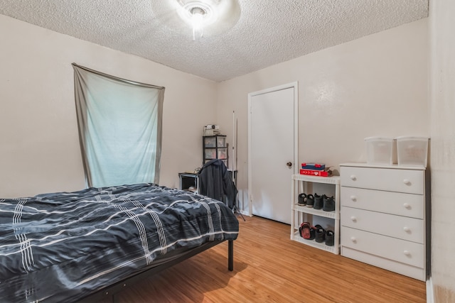 bedroom with light hardwood / wood-style flooring and a textured ceiling