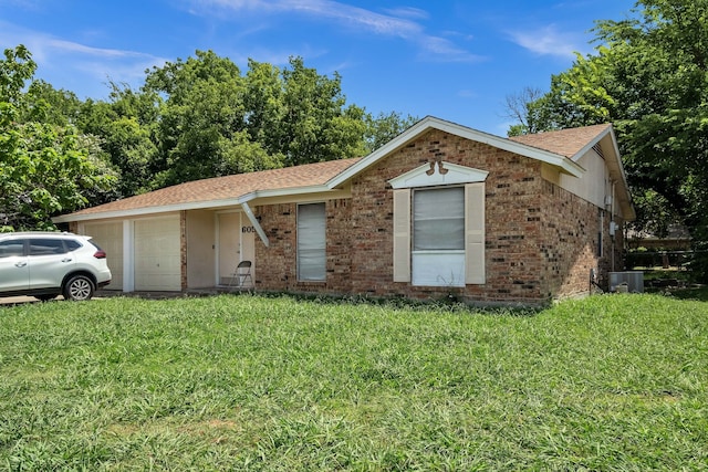 ranch-style house featuring central air condition unit, a garage, and a front lawn