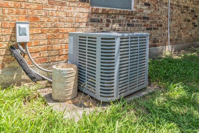 exterior details featuring brick siding and central air condition unit