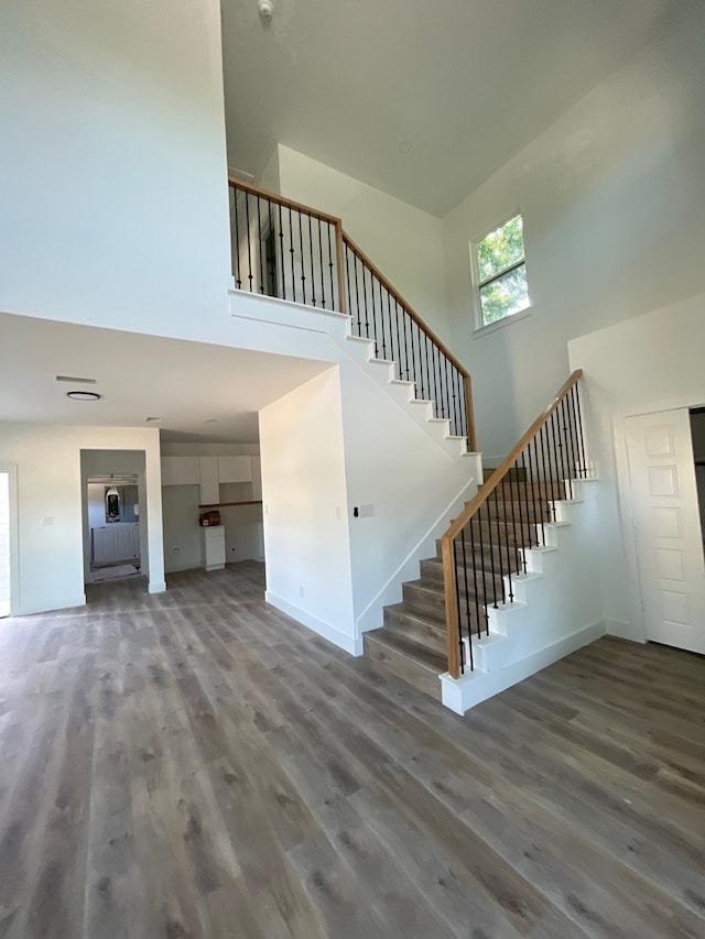 stairway featuring hardwood / wood-style flooring and a high ceiling