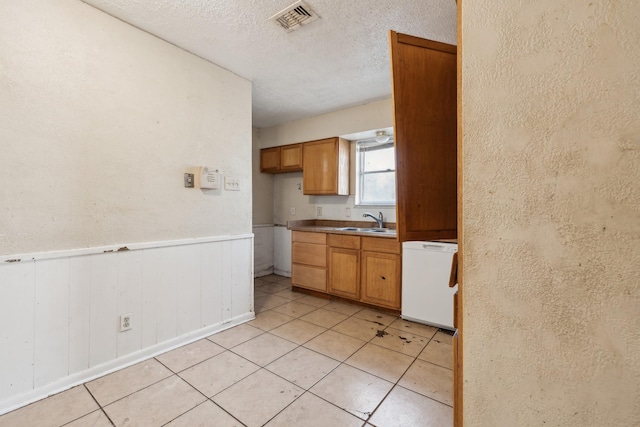 kitchen with sink, fridge, and a textured ceiling