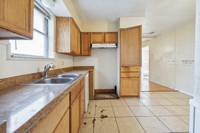 kitchen with sink, white dishwasher, and light tile patterned flooring