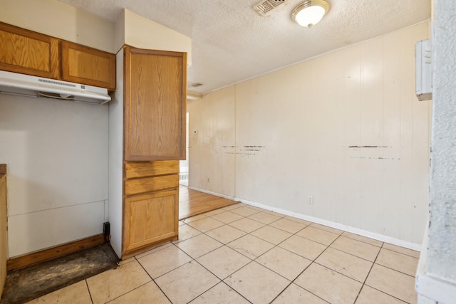 kitchen with a textured ceiling and light tile patterned floors