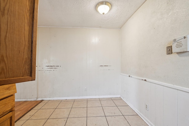 empty room featuring a textured ceiling and light tile patterned flooring