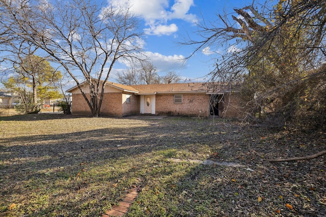 rear view of property featuring a lawn