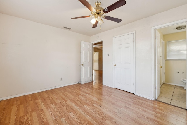 unfurnished bedroom featuring connected bathroom, ceiling fan, and light wood-type flooring