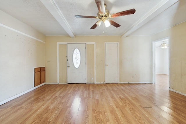 entryway with a textured ceiling, ceiling fan, light hardwood / wood-style flooring, and beamed ceiling