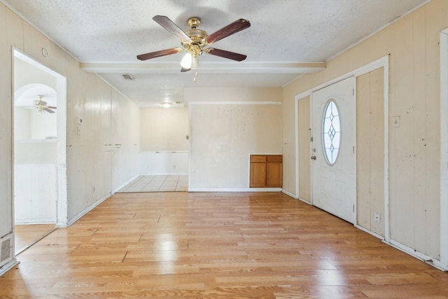 foyer with a textured ceiling, ceiling fan, light wood-type flooring, and beam ceiling