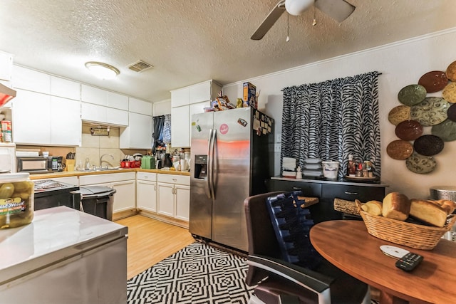 kitchen with white cabinetry, sink, tasteful backsplash, stainless steel fridge with ice dispenser, and a textured ceiling