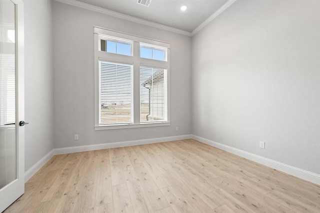 empty room with crown molding and light wood-type flooring