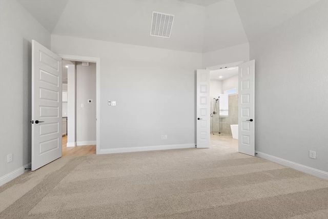 unfurnished bedroom featuring light colored carpet and a towering ceiling