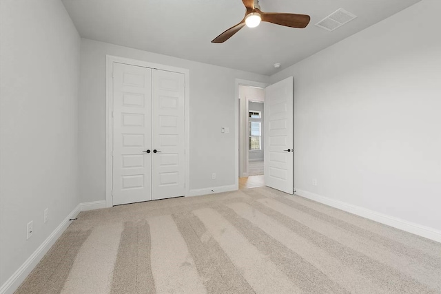 unfurnished bedroom featuring a closet, ceiling fan, and light colored carpet