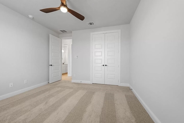 unfurnished bedroom with ceiling fan, light colored carpet, and a closet