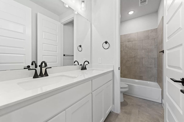 full bathroom with vanity, tiled shower / bath combo, and toilet