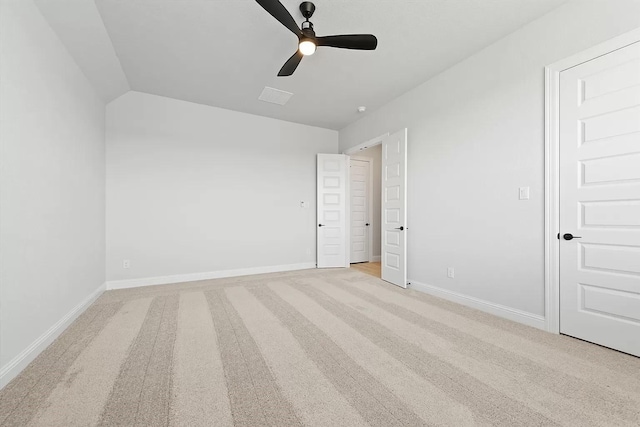 unfurnished bedroom featuring light carpet, vaulted ceiling, and ceiling fan