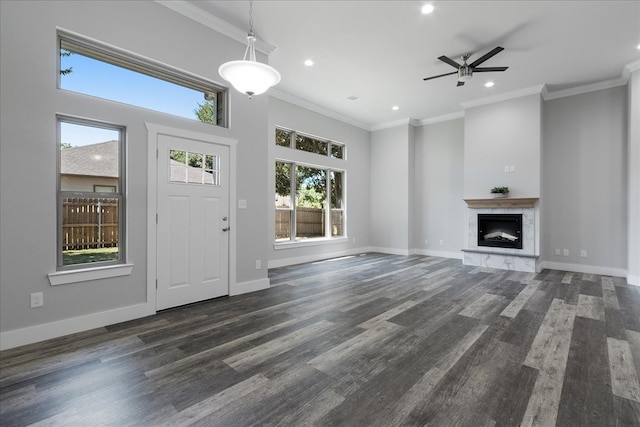 foyer entrance with dark wood-type flooring, a towering ceiling, ornamental molding, and ceiling fan