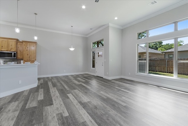 unfurnished living room with hardwood / wood-style flooring, crown molding, and plenty of natural light