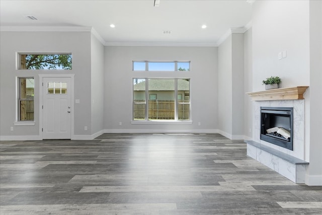 unfurnished living room with wood-type flooring, a premium fireplace, and plenty of natural light