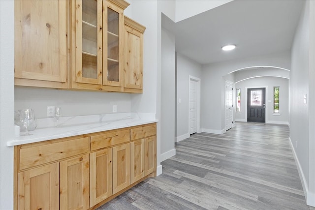 kitchen with light hardwood / wood-style floors, light stone counters, and light brown cabinets