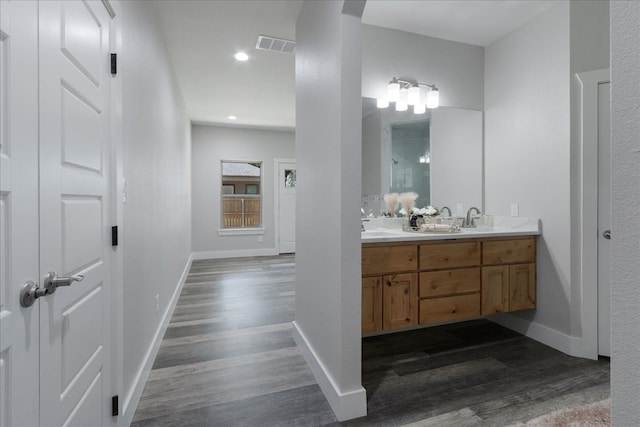 bathroom with wood-type flooring and dual bowl vanity