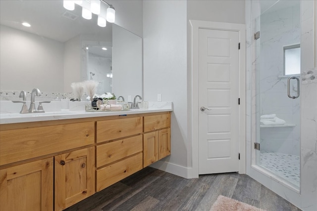 bathroom featuring an enclosed shower, hardwood / wood-style flooring, and double sink vanity