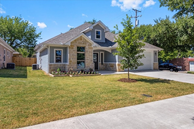 view of front of house with central air condition unit, a garage, and a front lawn