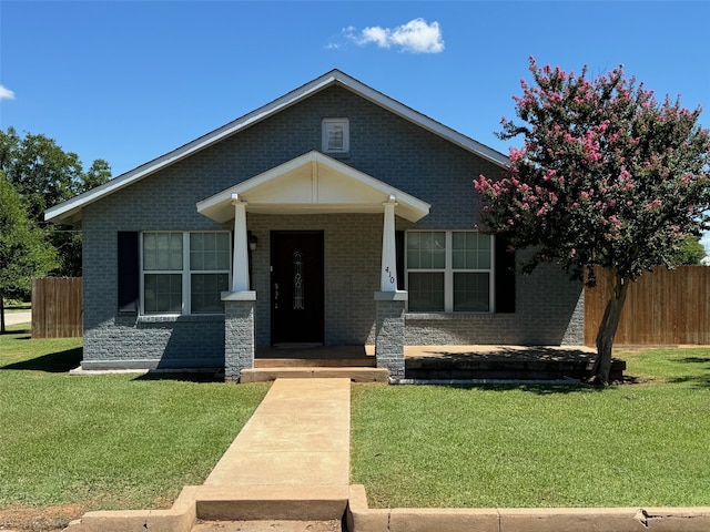 view of front of home with a porch and a front yard