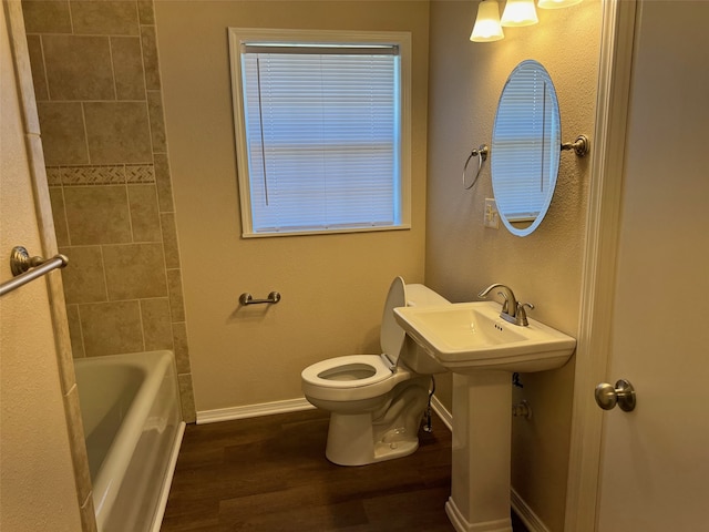 bathroom with bathtub / shower combination, hardwood / wood-style flooring, and toilet