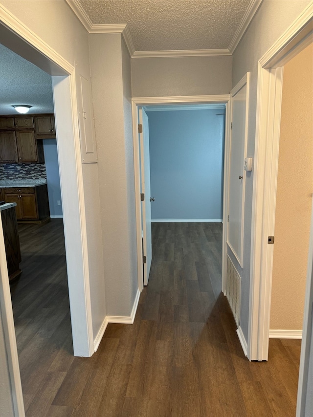 hallway with a textured ceiling, crown molding, and dark hardwood / wood-style floors