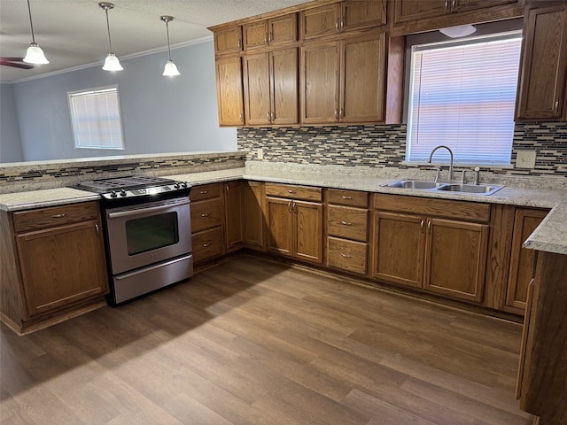 kitchen featuring gas stove, kitchen peninsula, dark hardwood / wood-style floors, hanging light fixtures, and sink