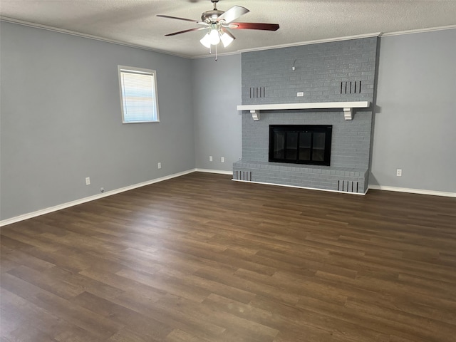 unfurnished living room featuring a fireplace, dark wood-type flooring, brick wall, and a textured ceiling