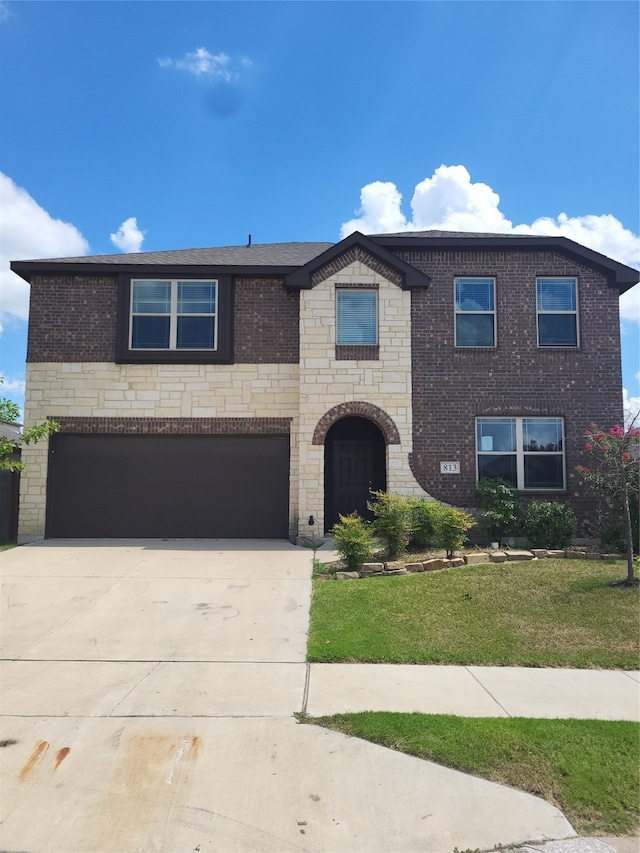 view of front of home with a garage and a front lawn