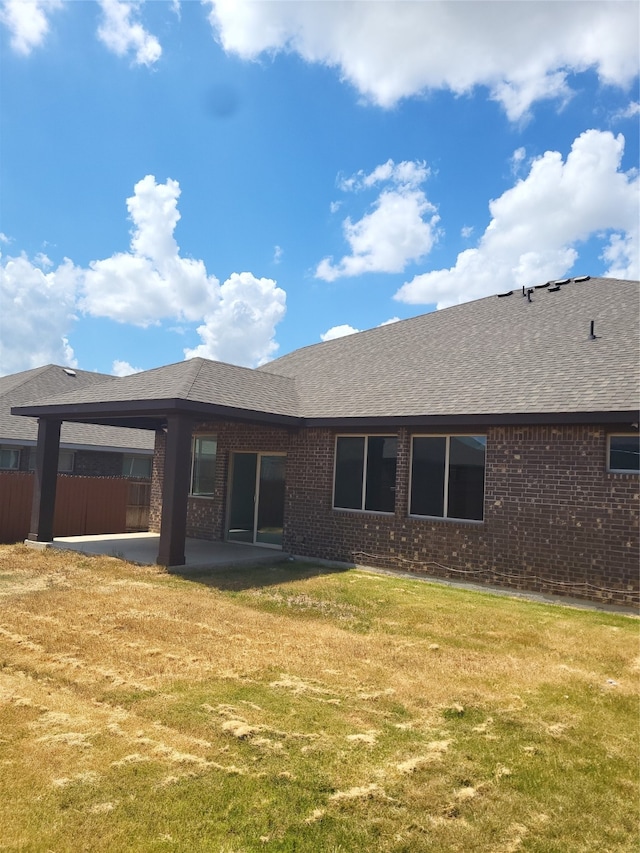 rear view of property featuring a patio and a lawn