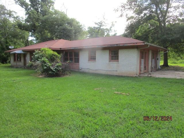 rear view of house featuring a garage and a lawn