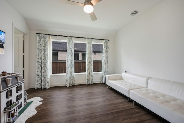 living room featuring dark hardwood / wood-style flooring, vaulted ceiling, and ceiling fan