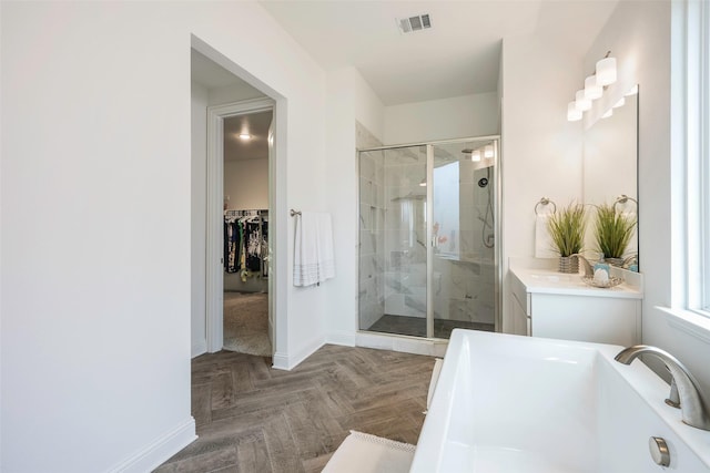 bathroom with parquet floors, vanity, and plus walk in shower