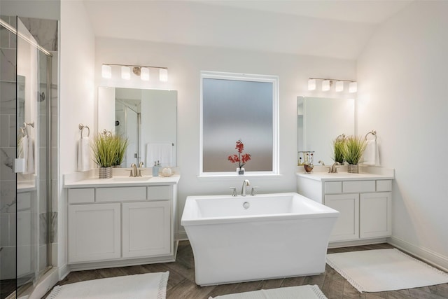 bathroom with hardwood / wood-style flooring, vanity, independent shower and bath, and vaulted ceiling