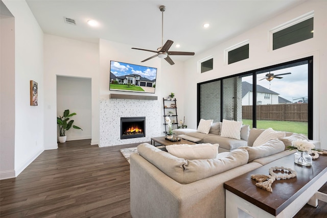 living room featuring a tiled fireplace and dark hardwood / wood-style floors