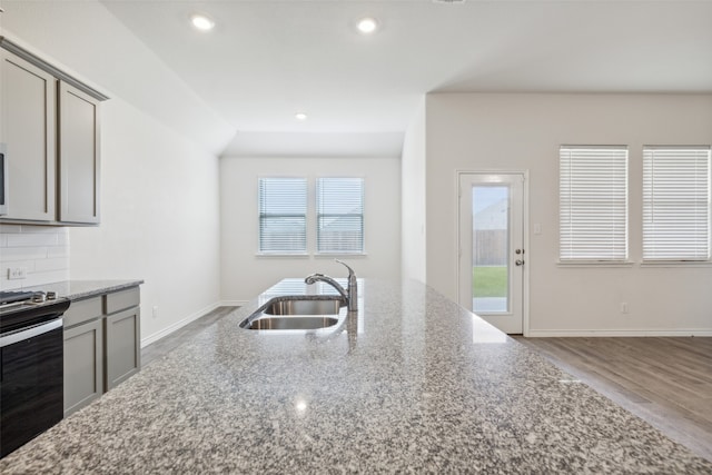 kitchen with tasteful backsplash, plenty of natural light, stone countertops, and light hardwood / wood-style floors