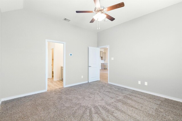 unfurnished bedroom featuring light colored carpet, high vaulted ceiling, and ceiling fan