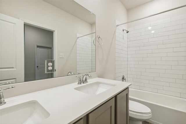 full bathroom with tiled shower / bath, toilet, and double vanity