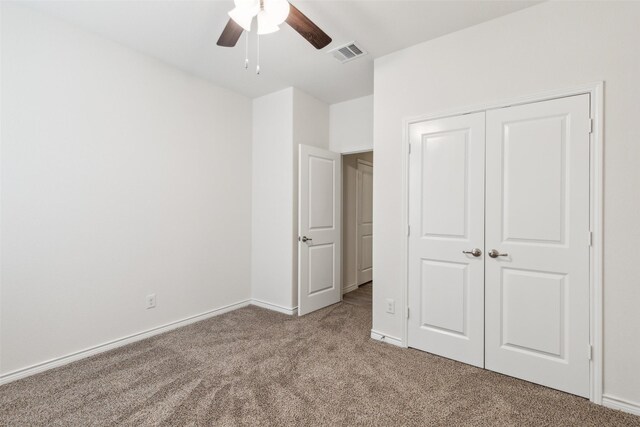 unfurnished bedroom featuring ceiling fan, a closet, and light carpet